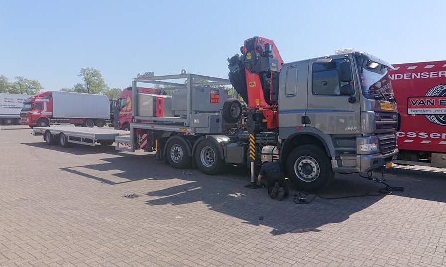 Op een parkeerplaats wordt een band van een truck gerepareerd